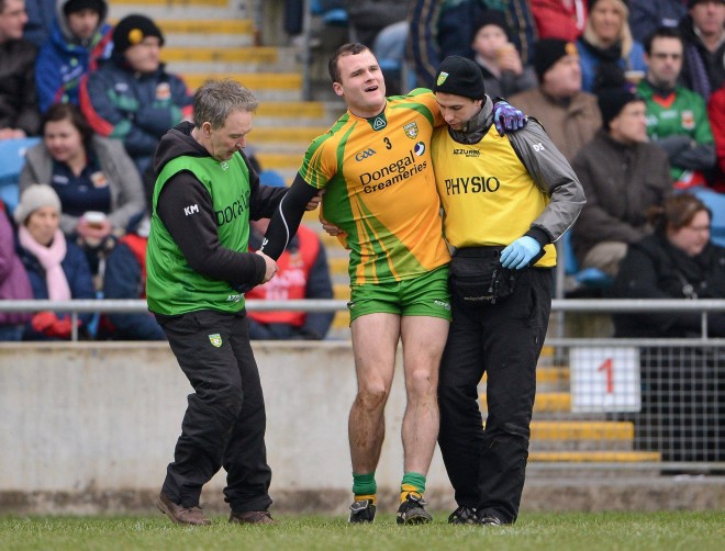 Neil McGee is assisted from the field by team doctor Dr. Kevin Moran, left, and team physiotherapist Dermot Simpson.