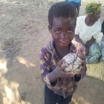 A young boy holds the ball made of plastic bags. The children were overjoyed when the group from Rathmullan brought them a proper football to play with. 