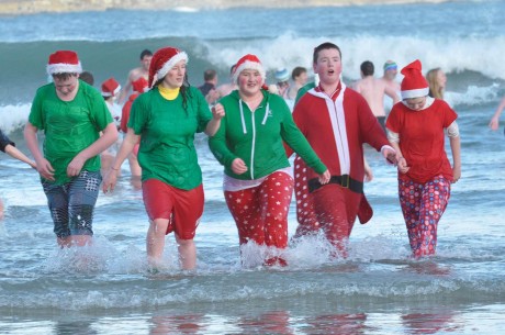 Swimmers in Christmas costumes at the Annual New Year's Swim at Marble Hill Beach.