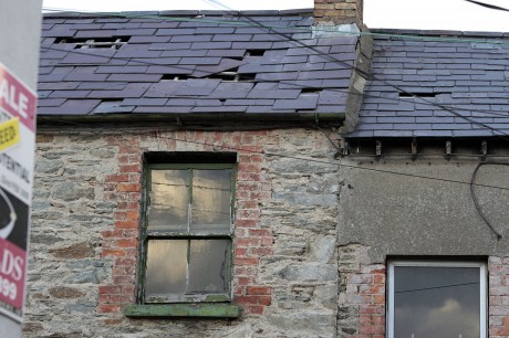 Loose slates and holes in the roof of a house on Church Lane.