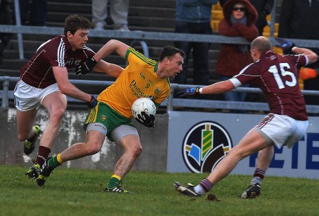 Donegal midfielder Martin McElhinney on the ball as two Galwy men move in to tackle,