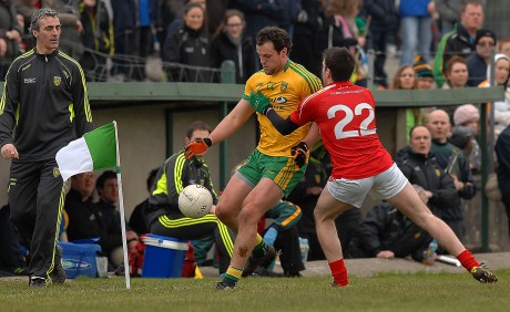 Michael Murphy gets his kick off to a team mate as manager Jim Mc Guinness looks on, in the league game in Fr. Tierney Park, Ballyshannon.