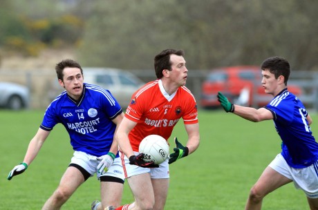 Michael McGinley, St Michaels in possession against AJ Gallagher and Ethan O'Donnell of Naomh Conaill.