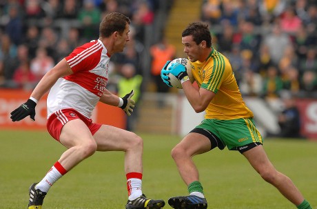 Odhran MacNiallais, taking on Patsy Bradley, Derry, as he sets his team on the attack.