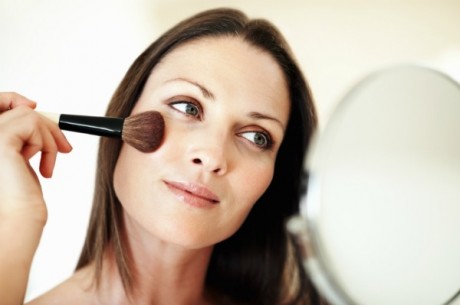 Closeup of pretty woman applying makeup
