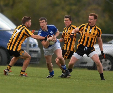 Leo McLoone on the burst for Naomh Conaill as Sean McVeigh and Eamonn Doherty of St Eunans, move in to halt his run.