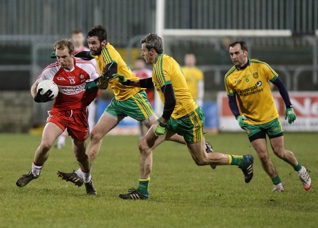 Derry's Sean Leo McGoldrick holds off Odhran Mac Niallais and Christy Toye.