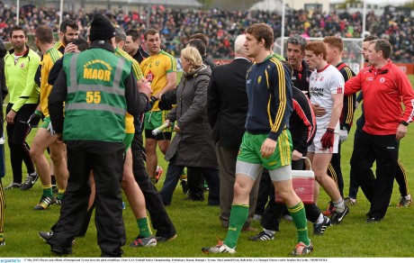 Players and officials of Donegal and Tyrone leave the pitch at half-time