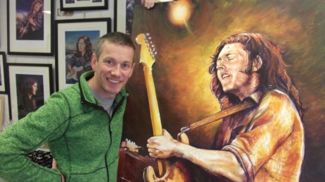 Ballyshannon artist Barry Sweeny with one of his Rory Gallagher portraits.
