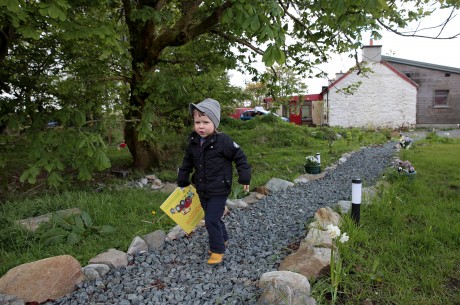 Fergus wanders the garden with the restored and extended cottage in the background.