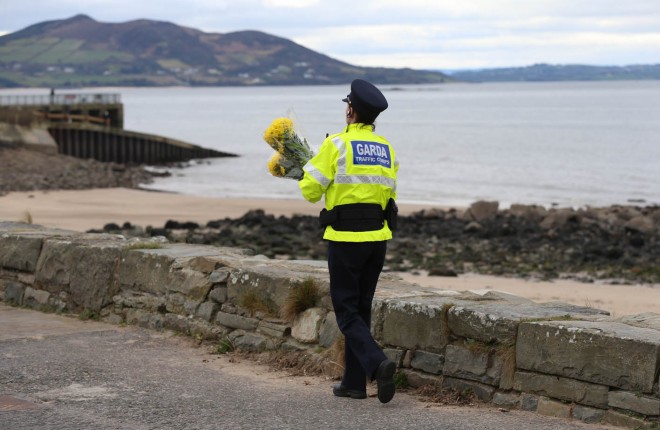 A Garda officer lays floral tributes close to where the tragedy occurred last night. 