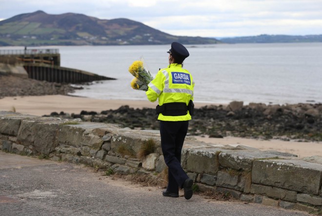 A Garda officer lays floral tributes close to where the tragedy occurred. 