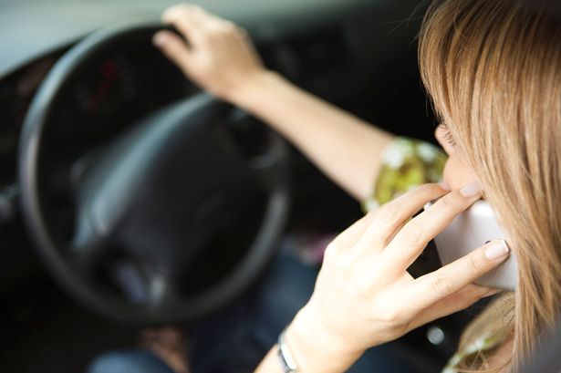 A motorist uses a mobile phone while driving. 
