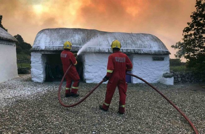Firefighters spray foam on to the roofs of thatched cottages to protect them from a nearby wild fire. Photos: Buncrana Fire and Rescue Service. 