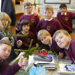 Caroline Mc Laughlin, SNA helping children at Scoil Cholmcille, Letterkenny make St Bridgid's Crosses on Wednesday.